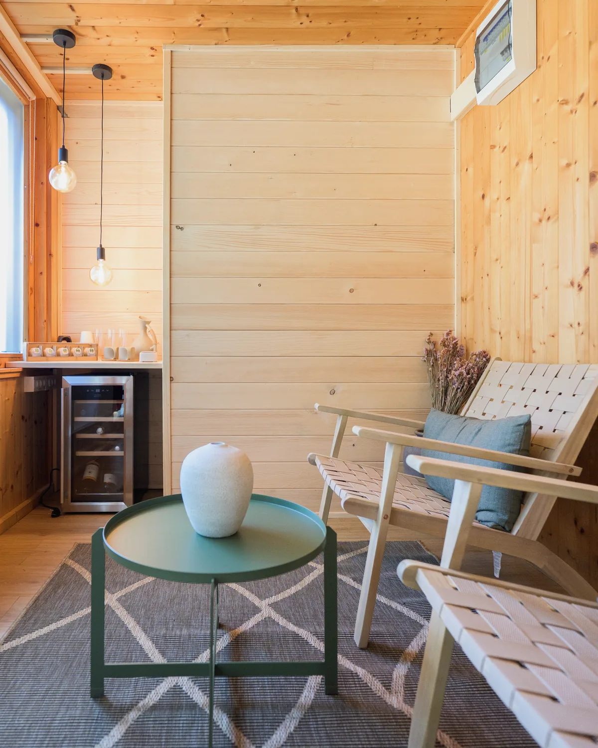 Warm wooden relaxation room with lounge chairs inside the forest SPA